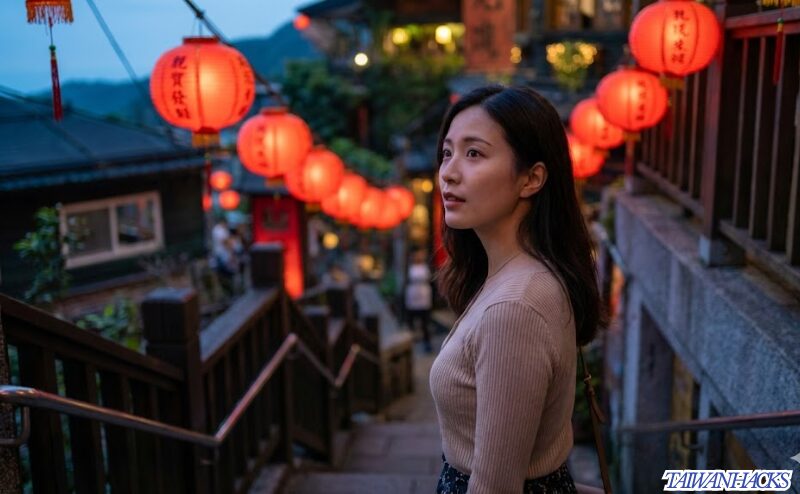 夕暮れの九份で赤提灯が灯る幻想的な景色を眺める日本人女性旅行者